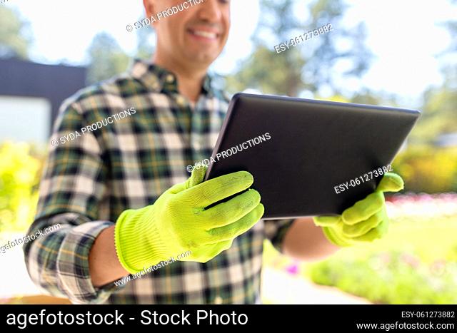 close up of man with tablet pc at summer garden