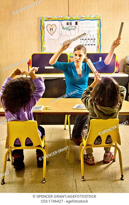 At the start of a in a special needs pre-Braille writing class at the Blind Children's Learning Center in Santa Ana, CA, a teacher adds movement by leading a...