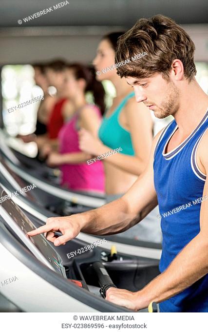 Smiling muscular man on treadmill