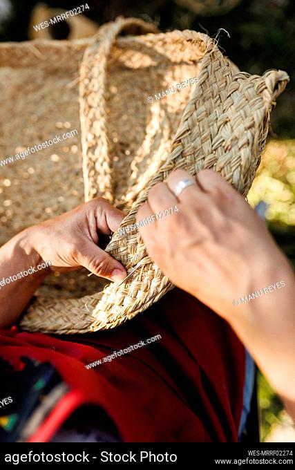 Hands of craftswoman weaving esparto grass basket