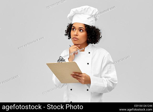 thinking female chef with clipboard and pen