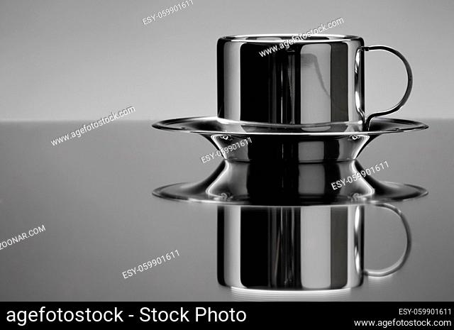 the beautiful still of one cup on mirror close , on grey background