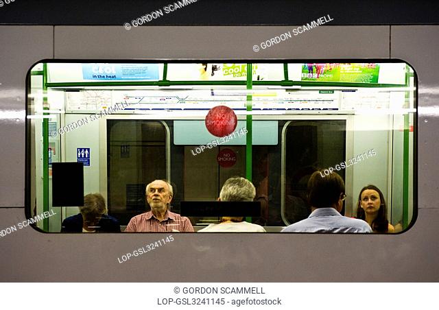 England, London, London. View through a window of passengers sitting inside a carriage of a London Underground train