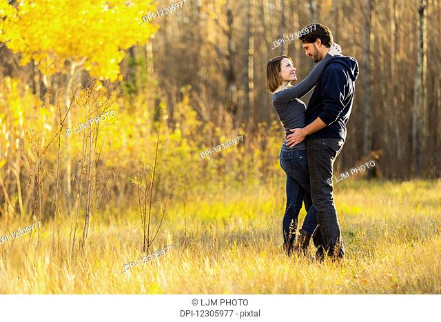 A young couple walking and enjoying each other's company in a city park in autumn; Edmonton, Alberta, Canada