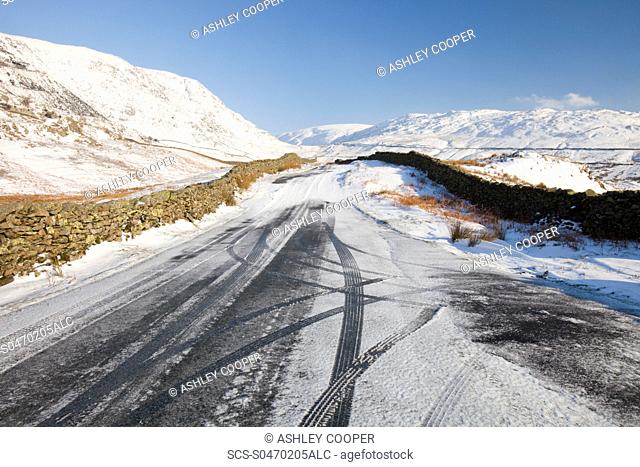 Tyre marks in the snow on Kirkstone Pass near Ambleside in the Lake District UK