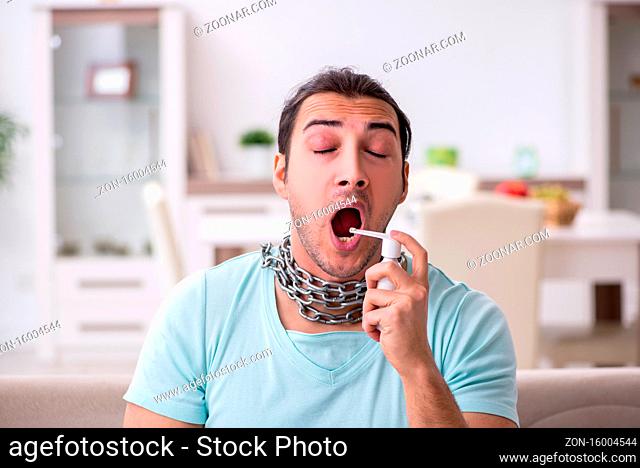 Young man suffering from sore throat at home