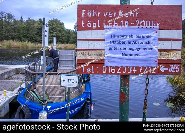PRODUCTION - 26 October 2023, Mecklenburg-Western Pomerania, Stolpe: A sign hangs at the pier of the small passenger ferry across the Peene and informs about...