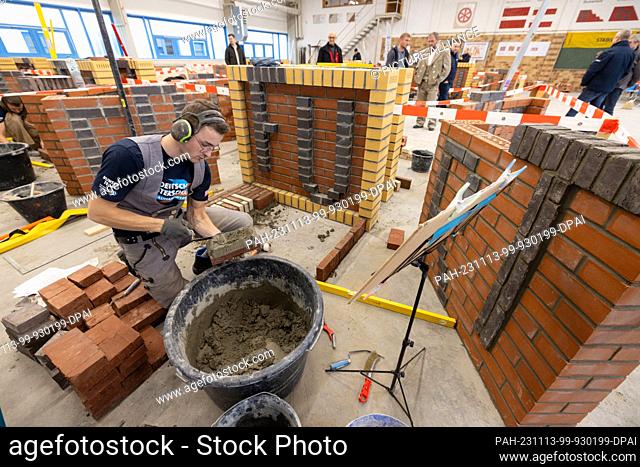 13 November 2023, Thuringia, Erfurt: Bricklayer Johannes Halbach (Thuringia) builds a decorative masonry wall from modules with the lettering ""Erfurt"" at the...