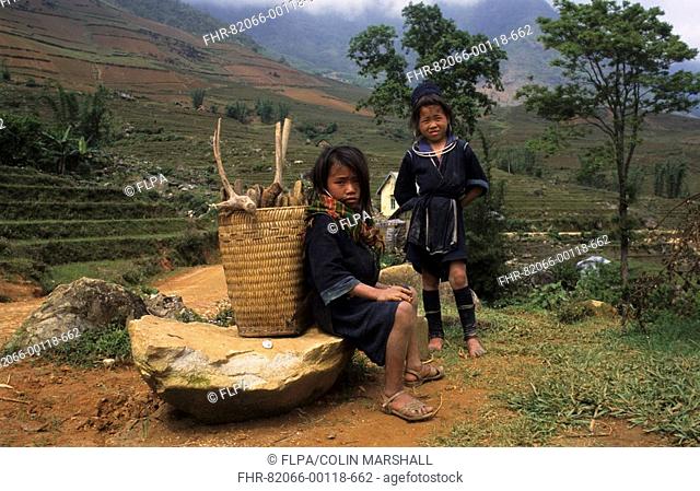 Vietnam - Black Hmong girl sitting with basket, another girl standing beside - between Sapa & Ta Van