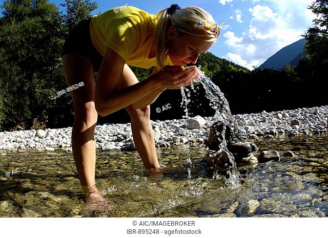 Woman, 22, refreshing herself while standing in a mountain stream, Kalkalpen National Park, Upper Austria, Austria, Europe