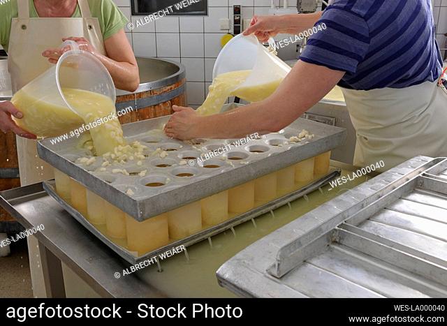 Germany, Baden Wuerttemberg, Women preparing cheese in industry, close up