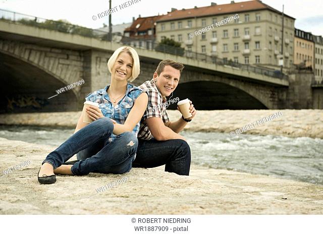 Young couple having a cup of coffee outdoors, Munich, Bavaria, Germany