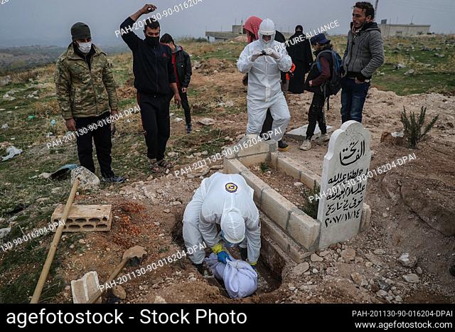 30 November 2020, Syria, Maratah: Specialized members of the Syrian Civil Defence, also known as the White Helmets, bury 7-month-old girl Ayat Hussein...