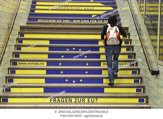 A view of an advert showing the flag of the European flag, a website and the question ""Questions oaboutn the EU?"" on a flight of stairs at subway station...