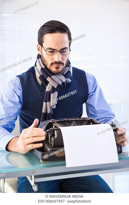 Serious businessman working on typewriter
