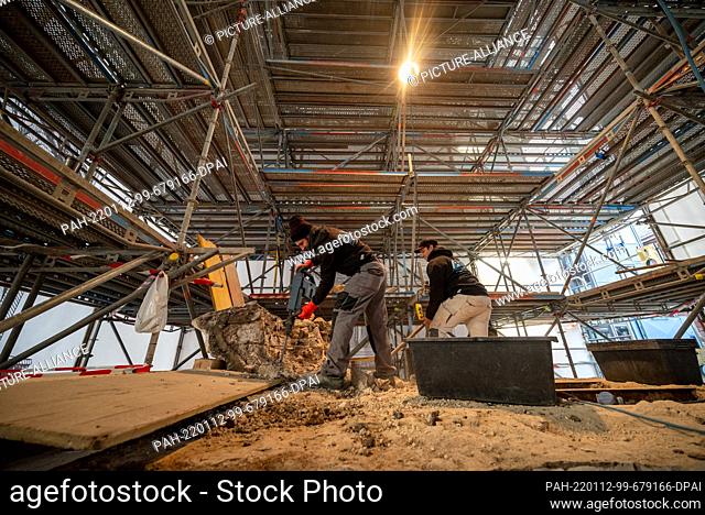 12 January 2022, Rhineland-Palatinate, Trier: A worker uses a jackhammer to pry parts out of the head of the 1:1 copy of the Unesco World Heritage Igel Column...