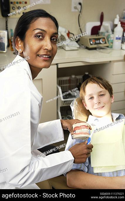 Female dentist showing patient a molding of teeth