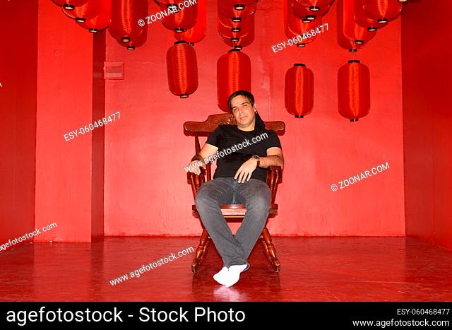 Portrait of handsome Persian man inside artistic red room