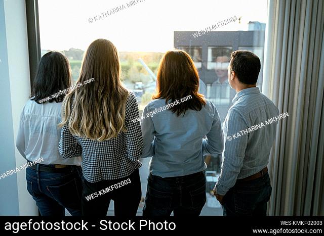 Rear view of business team looking out of window in office