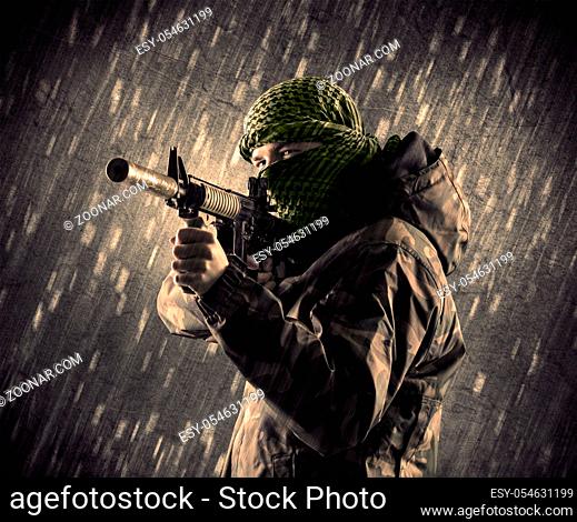 Close up of an armed terrorist man with mask on rainy background