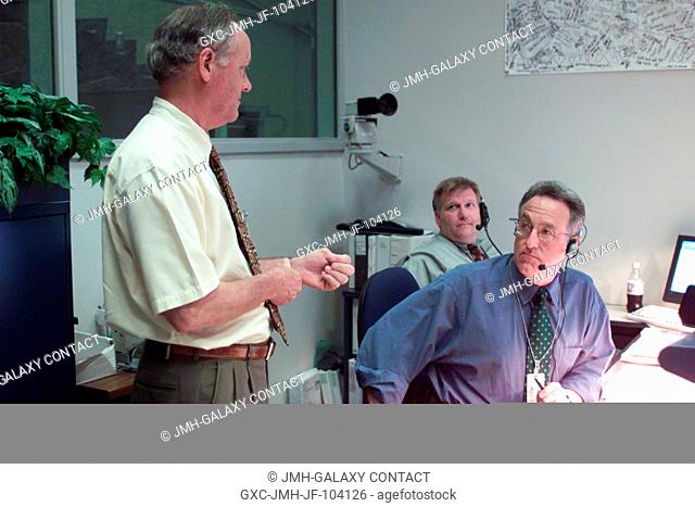 J. Milton (Milt) Heflin (standing), chief of the Flight Director's Office, along with Dan Carpenter (background), director of the Public Affairs Office