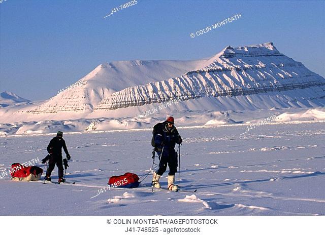 Ski tourers hauling sledges on spring traverse Ny Alesund to Longyearbyen Spitsbergen Island Svalbard Norwegian Arctic