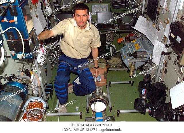 Yuri Malenchenko, Expedition Seven commander, prepares to use a window on the Zvezda service module for Earth observation purposes