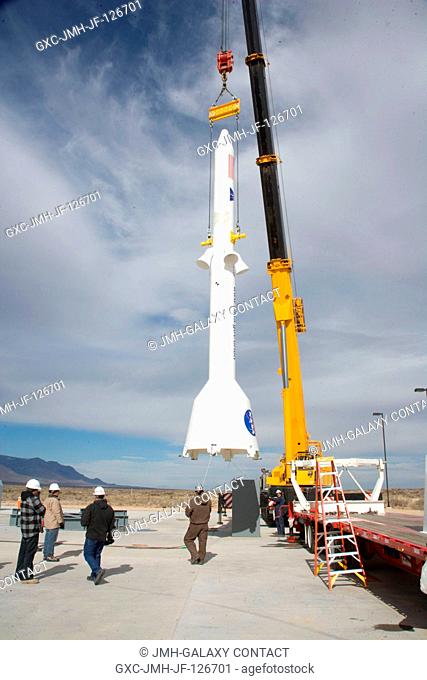 Technicians lift a mock-up launch abort system near the launch pad at the U.S. Army's White Sands Missile Range in New Mexico for the Pad Abort-1 (PA-1) flight...