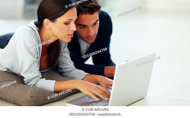 Loving young couple using a laptop together