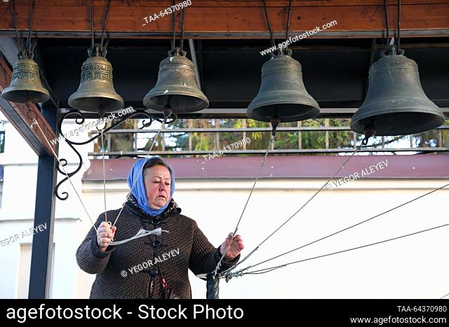RUSSIA, KAZAN - NOVEMBER 4, 2023: A woman rings bells at the Annunciation Cathedral of the Kazan Kremlin before a religious procession marking the feast day of...