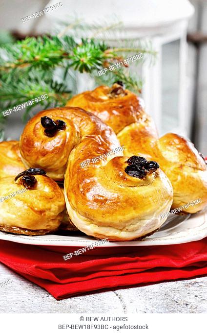 Traditional swedish buns in christmas setting. A saffron bun, in Swedish lussebulle or lussekatt
