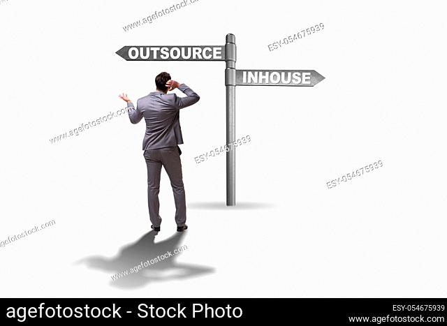 Businessman at crossroads deciding between outsourcing and inhouse
