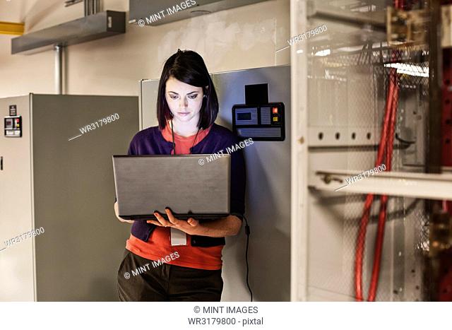 Caucasian woman technician working on computer servers in a server farm
