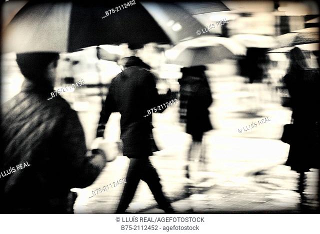 Blur unrecognizable peope with umbrellas on a rainy day in the city of London, England, UK, Europe