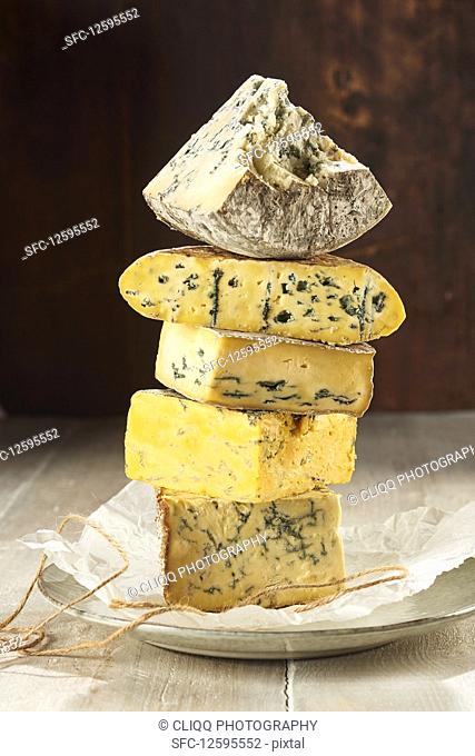 Selection of blue cheeses stacked up on paper