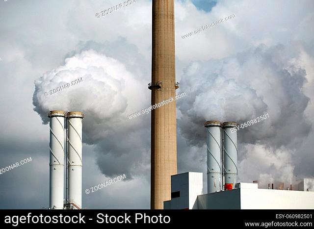 Smoking power plant chimney in an industrial area