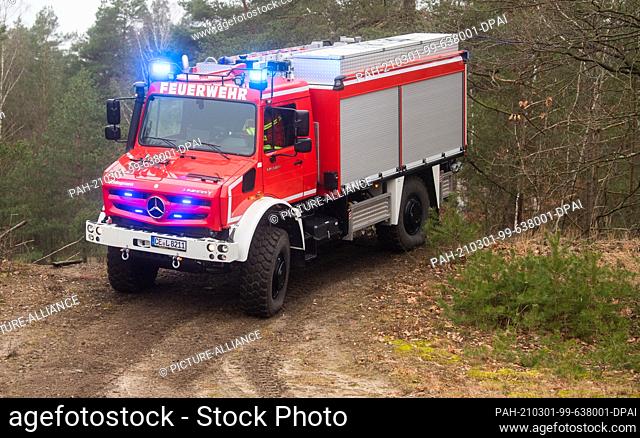 01 March 2021, Lower Saxony, Celle: A new forest fire tanker Unimog U5023 drives through the heath near the Lower Saxony State Office for Fire and Disaster...