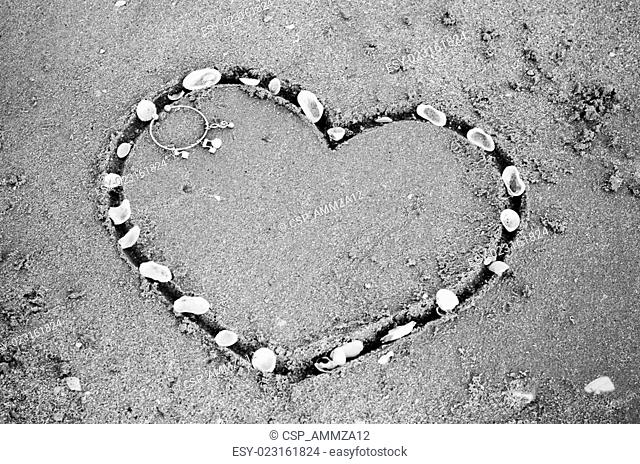 a heart on the sand in the beach black and white color tone style
