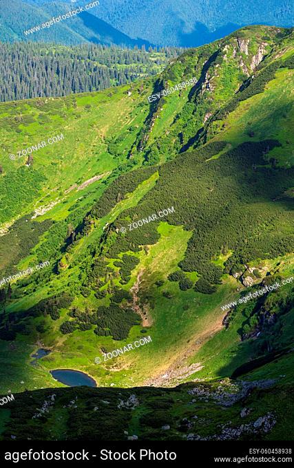 Summer mountain landscape with small lake in far. View from Marmaros Pip Ivan Mountain, Carpathian, Ukraine