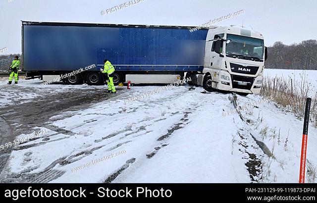 29 November 2023, Mecklenburg-Western Pomerania, Laage: A truck that has slipped away on a slippery road is parked on the A19 Rostock - Berlin highway in the...