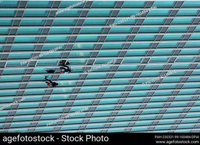 31 March 2023, Hamburg: Window cleaners rappel down the facade of the former Hamburg Süd-Haus, which is now called Trio Hamburg