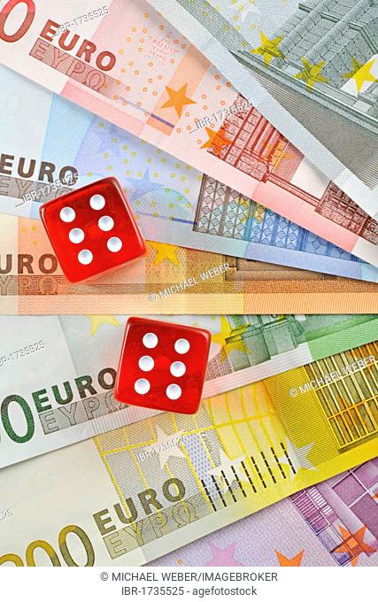 Various Euro banknotes arranged in a fan-shape with cubes, symbolic image for gambling