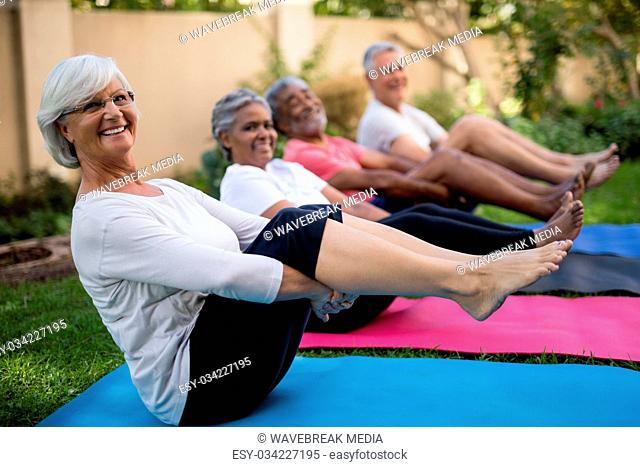 Smiling senior people exercising with feet up