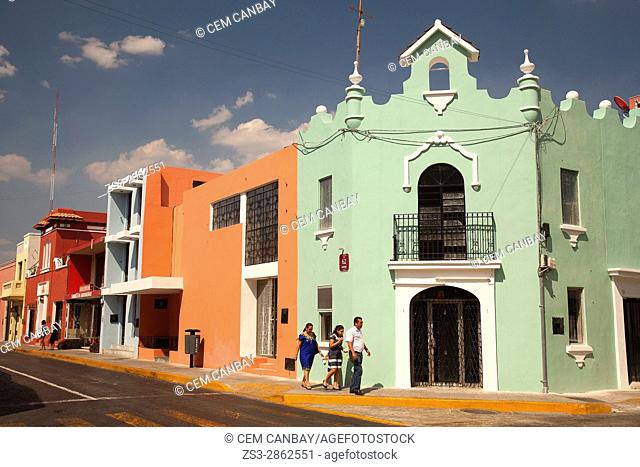 Local people walking in front of the colorful colonial buildings in the city center, Merida, Yucatan Province, Mexico, Central America