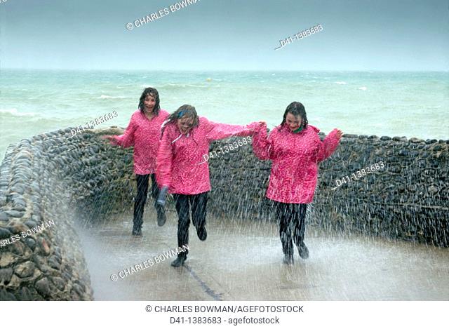 teenagers pink raincoats trio