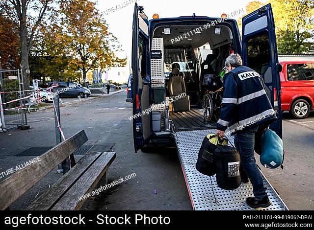 28 October 2021, Berlin: Cold bus driver Matthias Spreemann loads the cold bus with sleeping bags and prepares the vehicle for use
