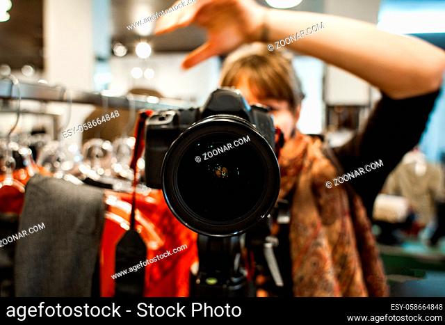 Self portrait of professional photographer with DSLR camera on tripod. Selective focus on the camera lens with blurred background
