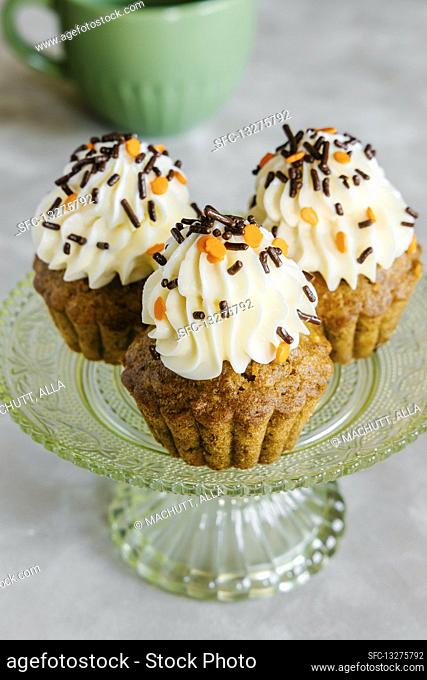 Spiced carrot and nut Autumn cupcakes, decorated with cream cheese frosting and sprinkles