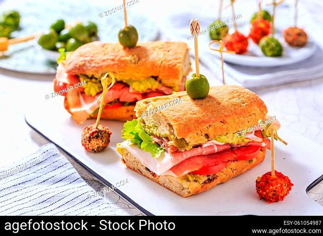 Homemade Ciabatta sandwich with guacamole, prosciutto, lettuce and tomato