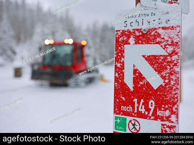06 December 2023, Saxony-Anhalt, Schierke: A cross-country ski trail groomer on the Renneckenberg trail near Schierke passes a trail sign